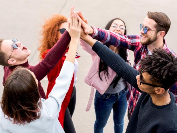 6 personer med forskellige frisyrer og hårfarve der giver hinanden high five